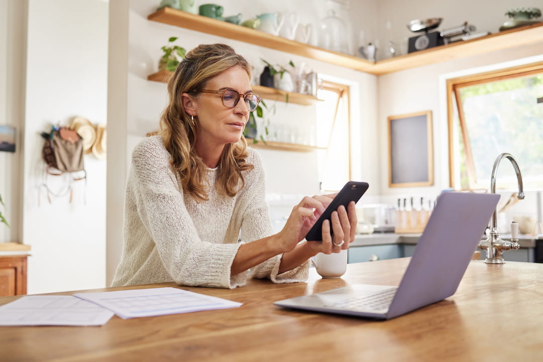 Woman looking at payments on phone wondering do I need to lodge a tax return on Centrelink?